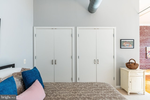 bedroom featuring two closets and light colored carpet