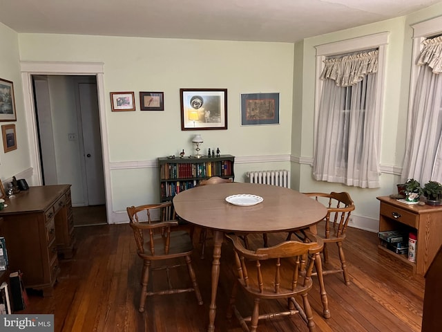 dining area with radiator and dark hardwood / wood-style flooring