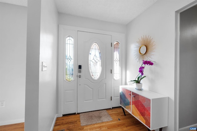 entryway featuring hardwood / wood-style floors and a textured ceiling