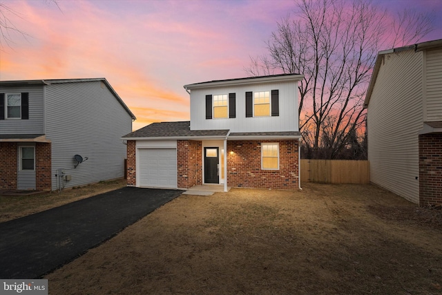 front facade with a garage and a lawn