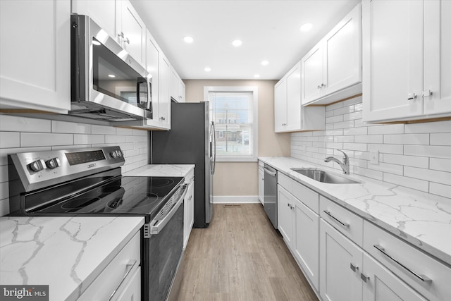 kitchen with appliances with stainless steel finishes, sink, and white cabinets