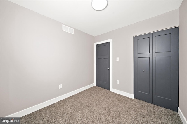 unfurnished bedroom featuring a closet and carpet flooring