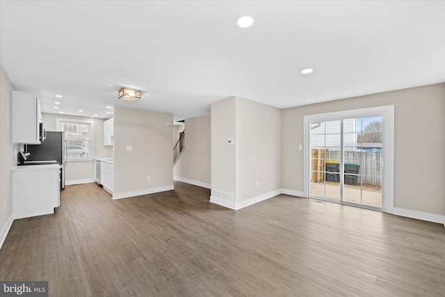 unfurnished living room featuring a healthy amount of sunlight and hardwood / wood-style floors