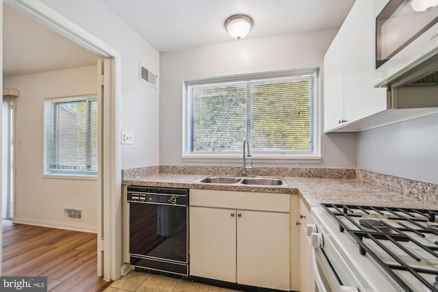 kitchen with sink, light hardwood / wood-style flooring, white range with gas stovetop, dishwasher, and white cabinetry