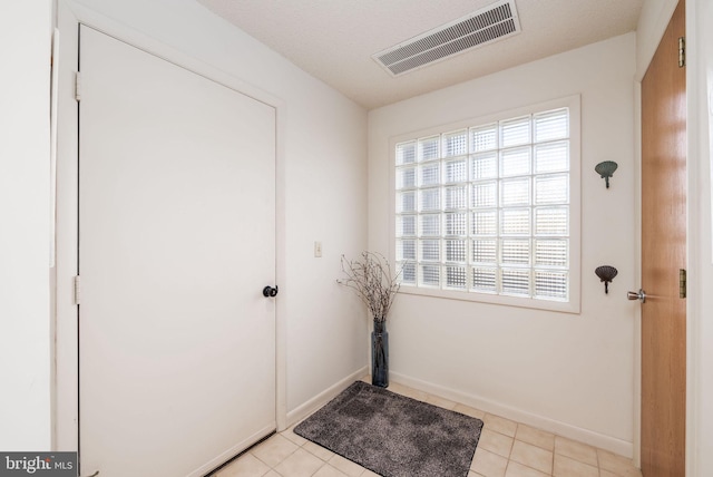 entryway featuring light tile patterned floors, baseboards, and visible vents