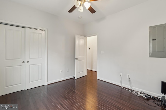 unfurnished bedroom featuring dark hardwood / wood-style flooring, electric panel, a closet, and ceiling fan