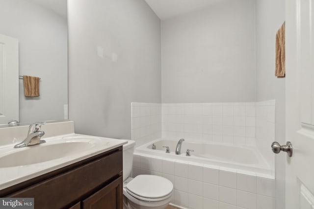 bathroom with vanity, a relaxing tiled tub, and toilet