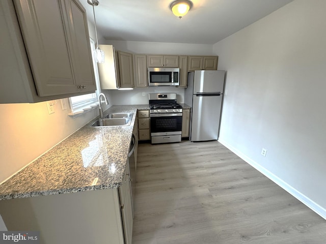 kitchen with sink, appliances with stainless steel finishes, gray cabinetry, light stone countertops, and decorative light fixtures