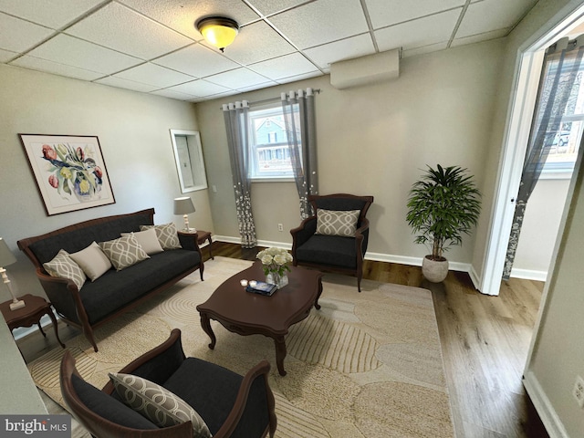 living room featuring hardwood / wood-style flooring and a paneled ceiling