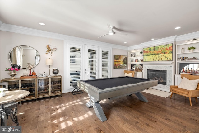 recreation room featuring crown molding, wood-type flooring, pool table, and a high end fireplace