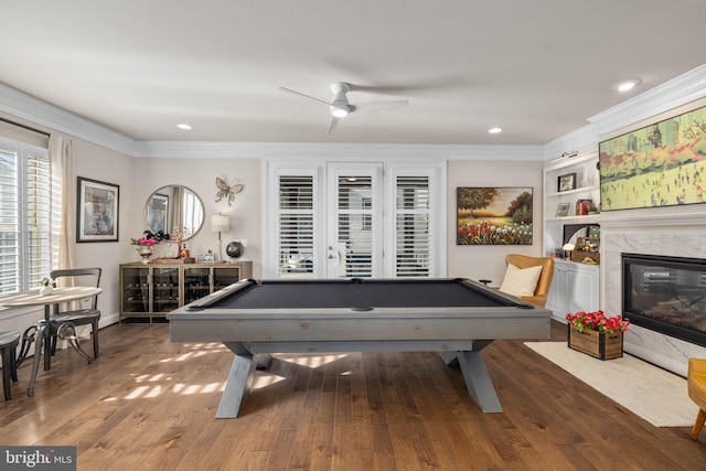 playroom featuring crown molding, billiards, dark hardwood / wood-style flooring, and a fireplace