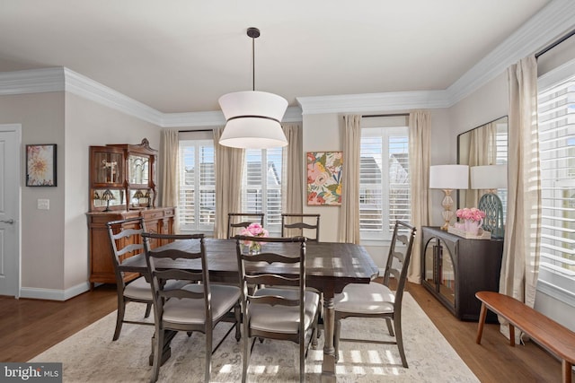 dining area featuring ornamental molding and wood-type flooring