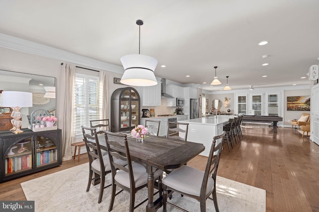 dining area with crown molding and hardwood / wood-style floors