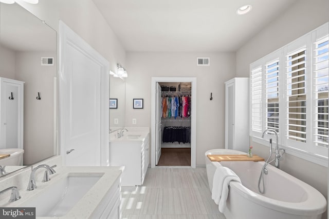 bathroom featuring a washtub and vanity