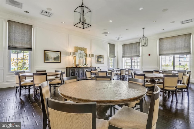 dining area with dark hardwood / wood-style flooring, crown molding, and plenty of natural light