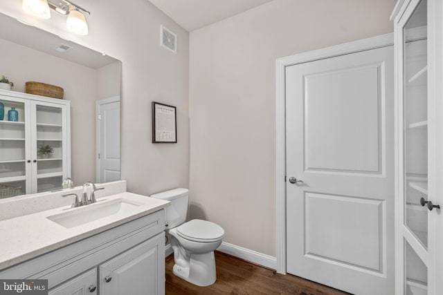 bathroom with hardwood / wood-style flooring, vanity, and toilet