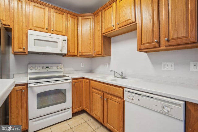 kitchen with light tile patterned floors, white appliances, and sink