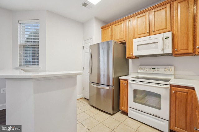 kitchen featuring light tile patterned floors and white appliances