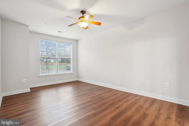 spare room with dark wood-type flooring and ceiling fan