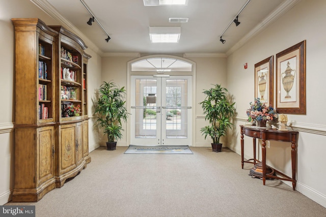 entryway featuring track lighting, ornamental molding, and carpet flooring