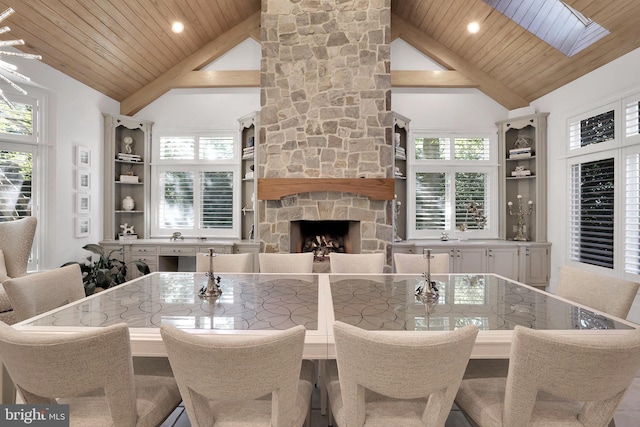 dining room with wood ceiling, a fireplace, and high vaulted ceiling