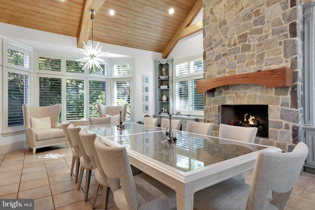 dining room with light tile patterned floors, wood ceiling, a fireplace, and high vaulted ceiling