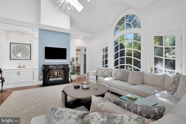 living area with high vaulted ceiling, a skylight, and a fireplace with flush hearth