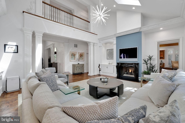 living area with ornate columns, a fireplace with flush hearth, baseboards, and recessed lighting