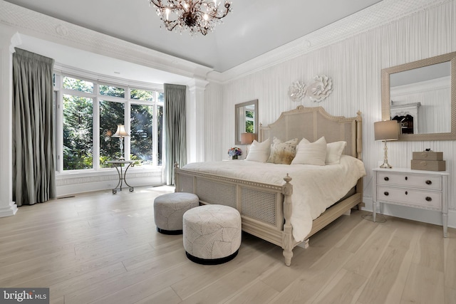 bedroom with light wood-type flooring, ornate columns, a chandelier, and crown molding