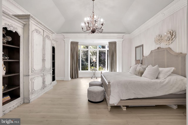 bedroom with vaulted ceiling, light wood finished floors, a chandelier, and ornate columns