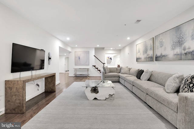 living room featuring stairs, visible vents, dark wood finished floors, and recessed lighting