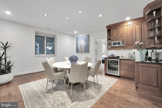 dining room with wine cooler, baseboards, light wood finished floors, and recessed lighting