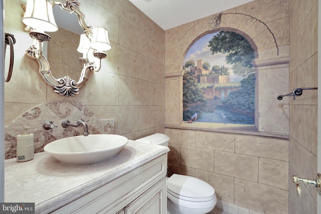 bathroom with tasteful backsplash, toilet, tile walls, and vanity