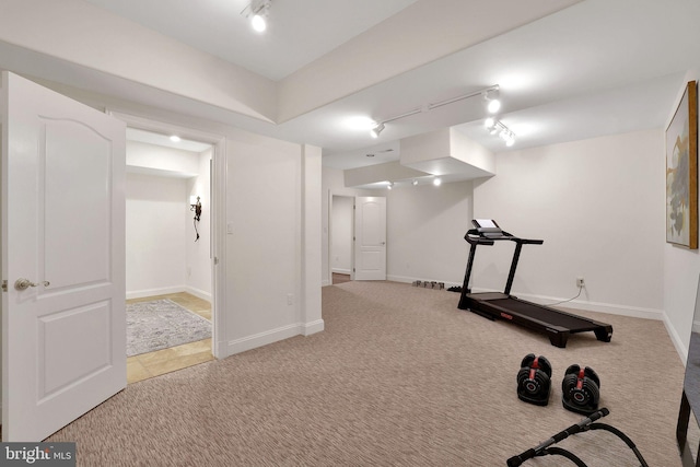 exercise room featuring rail lighting, carpet flooring, and baseboards