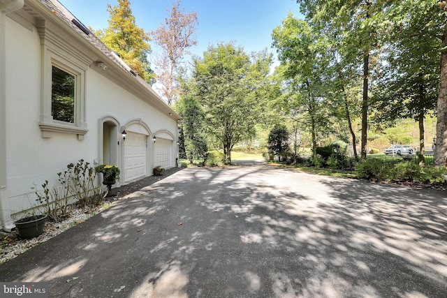 exterior space with driveway, a garage, and stucco siding