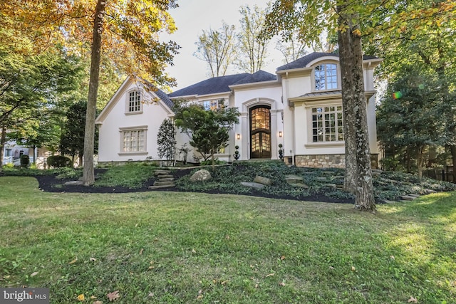 view of front of house with a front yard and stucco siding