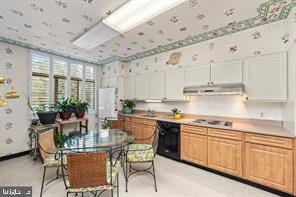 kitchen with black dishwasher, white stovetop, and white cabinets