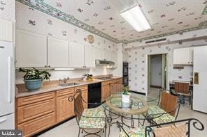 kitchen with sink, black dishwasher, white cabinets, and white fridge