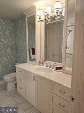 bathroom featuring vanity, toilet, tile patterned flooring, and a notable chandelier