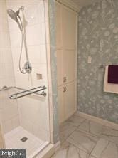 bathroom with a tile shower and tile patterned floors