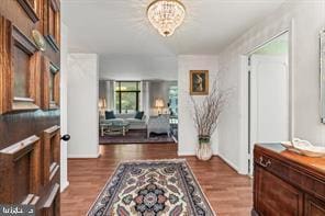 entrance foyer with an inviting chandelier and dark wood-type flooring