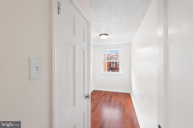 hallway featuring dark hardwood / wood-style flooring and a textured ceiling