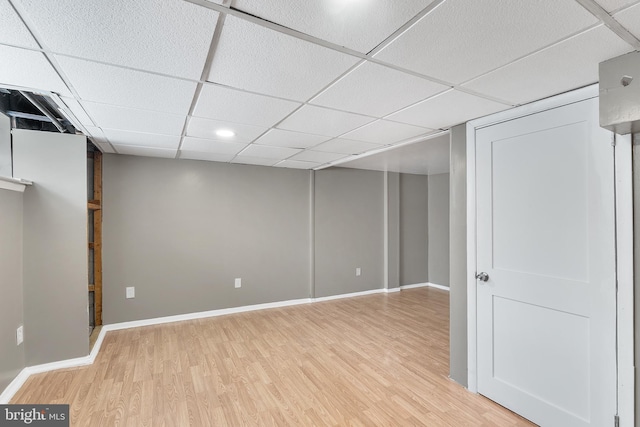 basement with a drop ceiling and light wood-type flooring