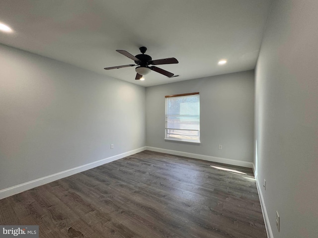 spare room with dark wood-type flooring and ceiling fan