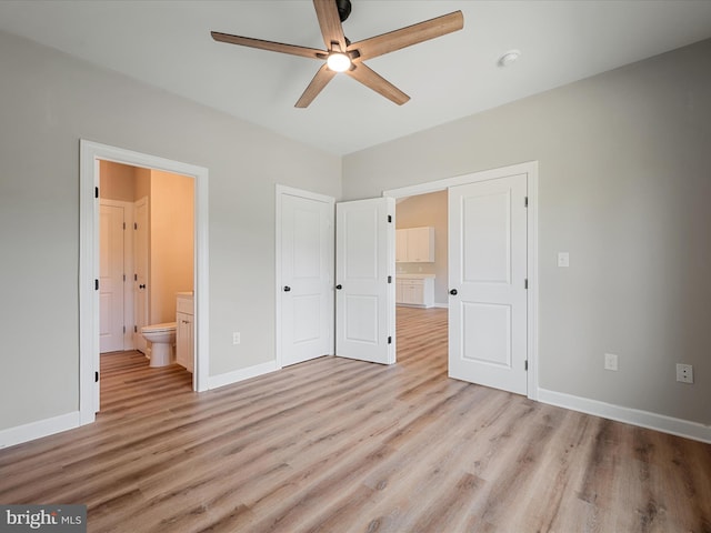 unfurnished bedroom featuring connected bathroom, baseboards, and light wood finished floors