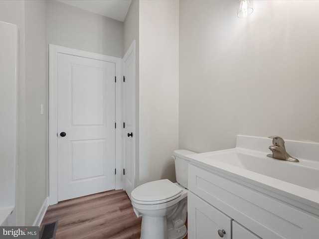 bathroom with visible vents, wood finished floors, toilet, and vanity