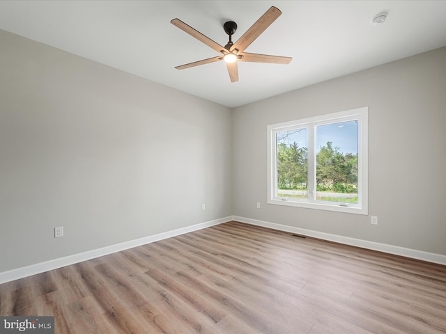 unfurnished room featuring baseboards, ceiling fan, wood finished floors, and visible vents