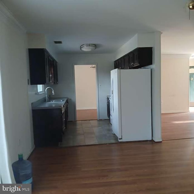 kitchen with sink, hardwood / wood-style floors, and white fridge