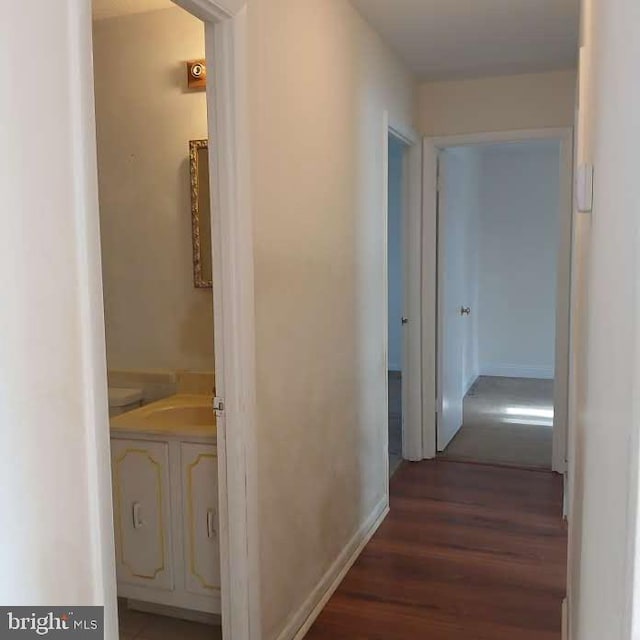 corridor with dark hardwood / wood-style flooring