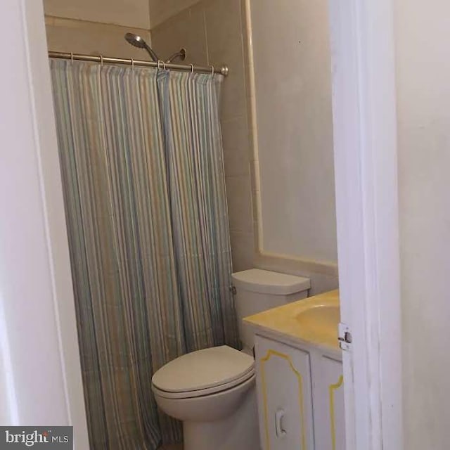 bathroom featuring vanity, a shower with curtain, and toilet